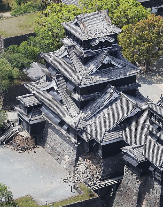 Зруйнована черепичний покрівлю та кам'яна кладка в замку Кумамото