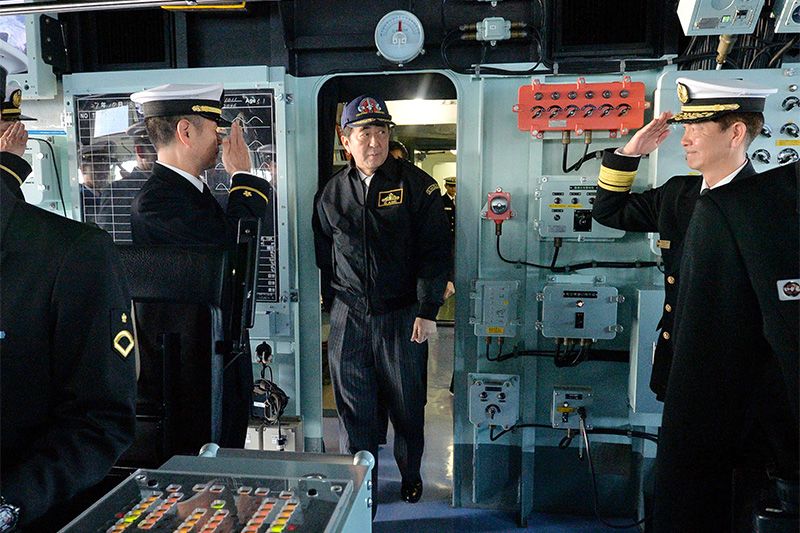Прем'єр-міністр Японії Абе Сіндзо (посередині) оглядає вертолётонесущій есмінець «Идзумо» в ході огляду Морських сил самооборони 18 жовтня 2015 р затоці Сагами біля узбережжя префектури Канагава (офіційна зйомка, фотографія надана Jiji Press)